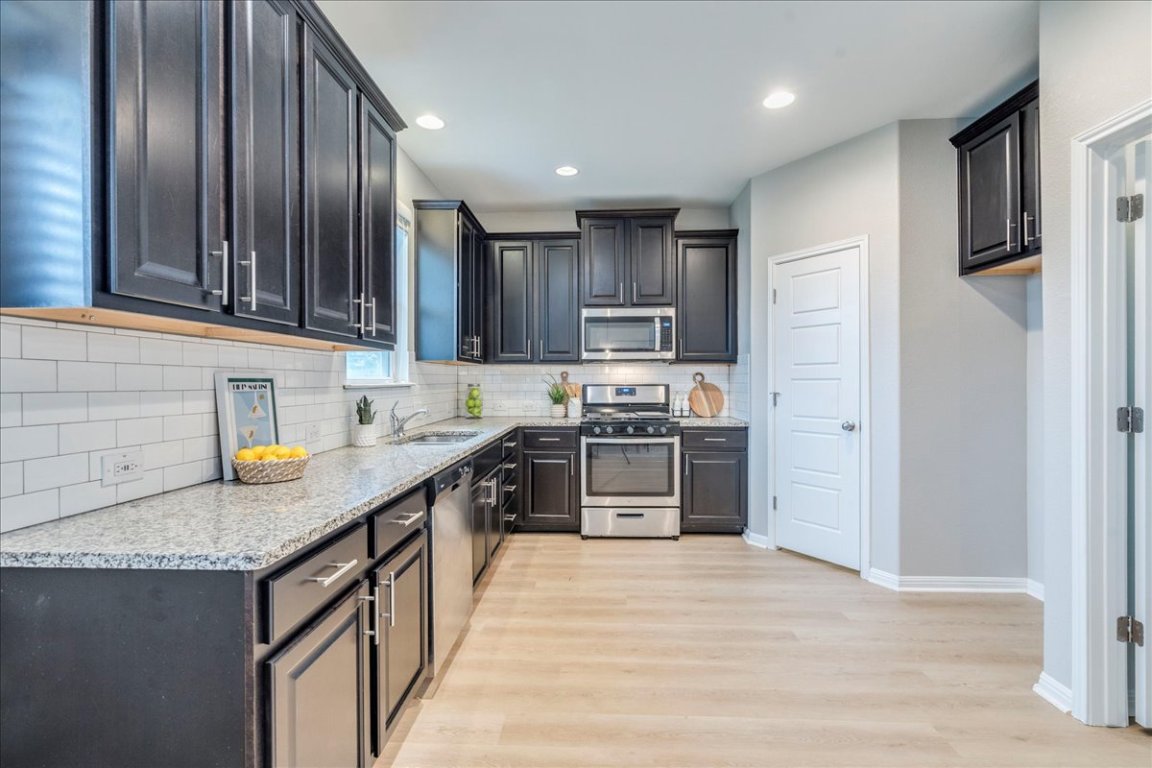 10317 Laurie Lane Austin, TX 78747 - Photo 2 of 35 a kitchen with stainless steel appliances granite countertop a refrigerator a stove top oven a sink and dishwasher