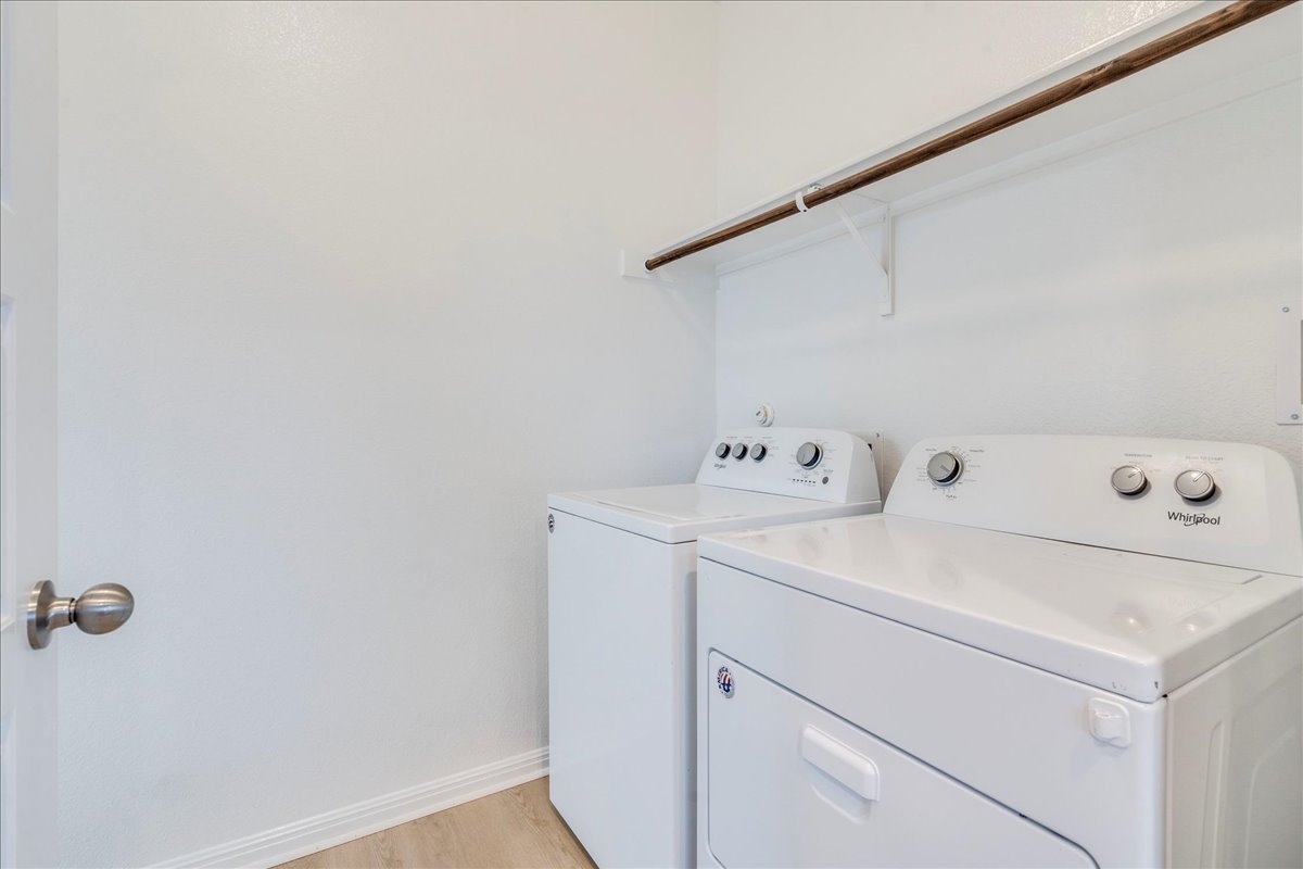 10317 Laurie Lane Austin, TX 78747 - Photo 23 of 35 Laundry area featuring washer and dryer and light wood finished floors