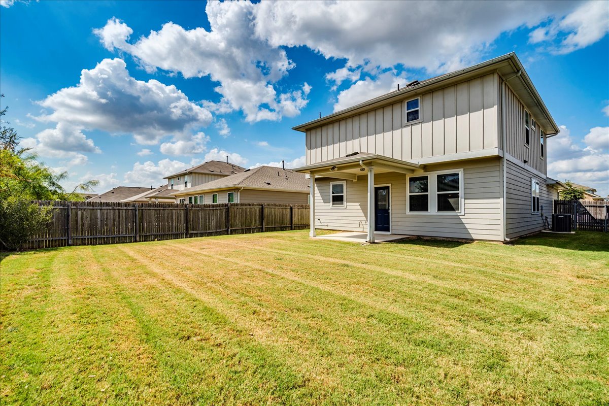 10317 Laurie Lane Austin, TX 78747 - Photo 26 of 35 Rear view of property featuring a patio, a fenced backyard, and board and batten siding