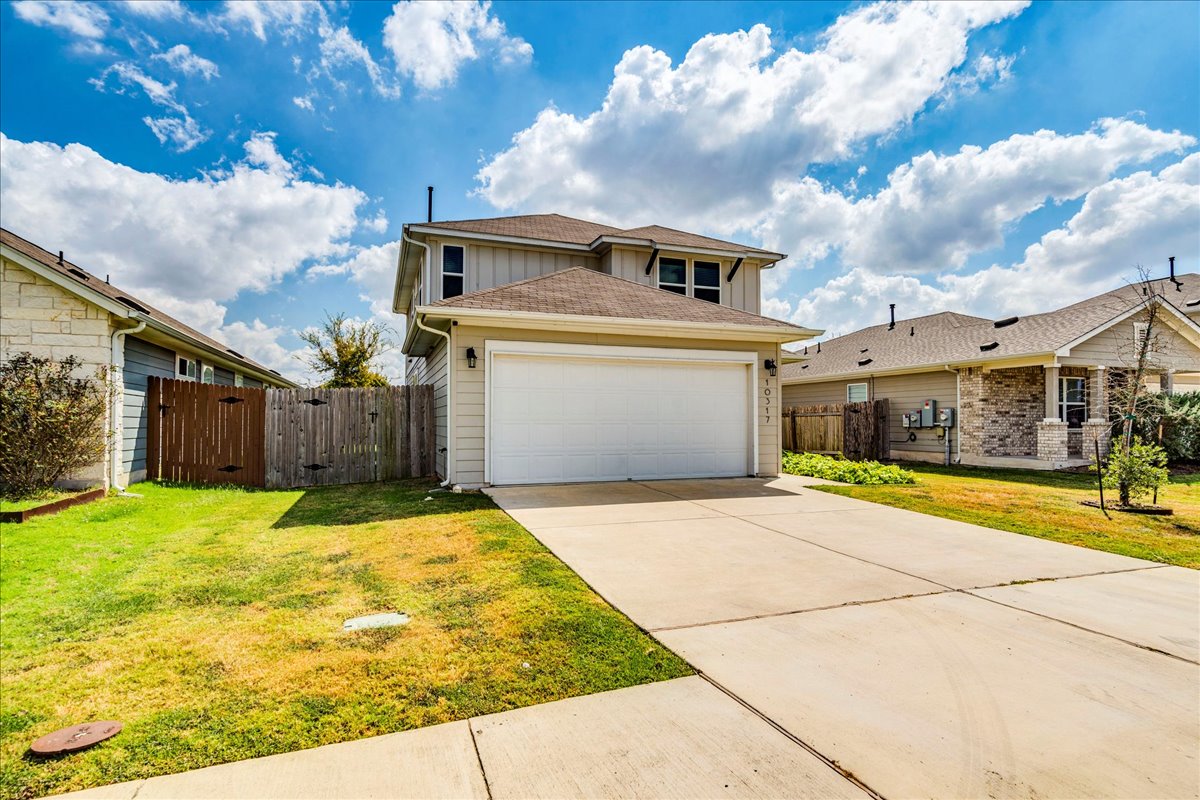 10317 Laurie Lane Austin, TX 78747 - Photo 29 of 35 Traditional-style home with board and batten siding, concrete driveway, a shingled roof, and a gate
