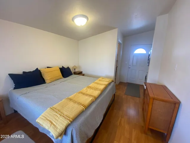 a bedroom with a bed and wooden floor