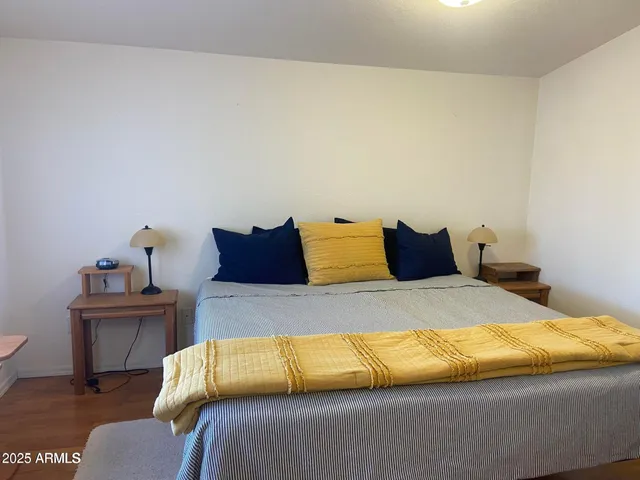 a bedroom with a bed and wooden floor