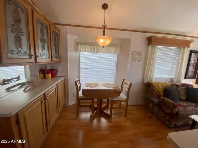 a kitchen with a dining table chairs sink and cabinets