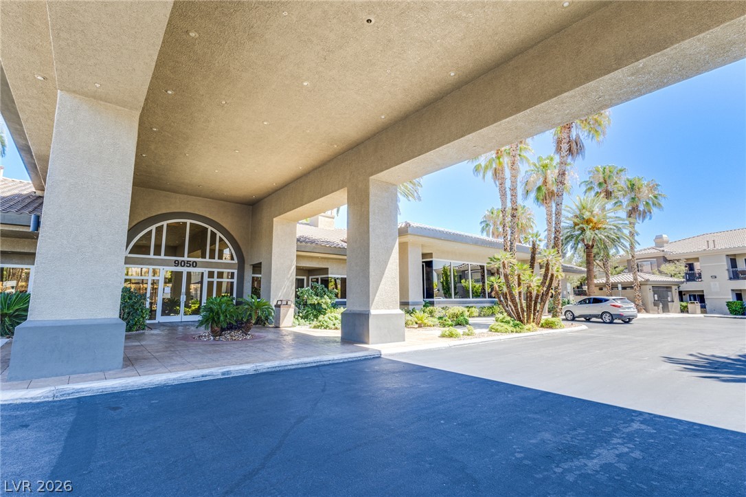 9050 West Warm Springs Road, Unit 1011 Las Vegas, NV 89148 - Photo 20 of 32 A grand entrance with an arched doorway and surrounding palms welcomes all to this community.