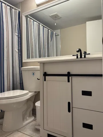 a bathroom with a sink a toilet a mirror and shower