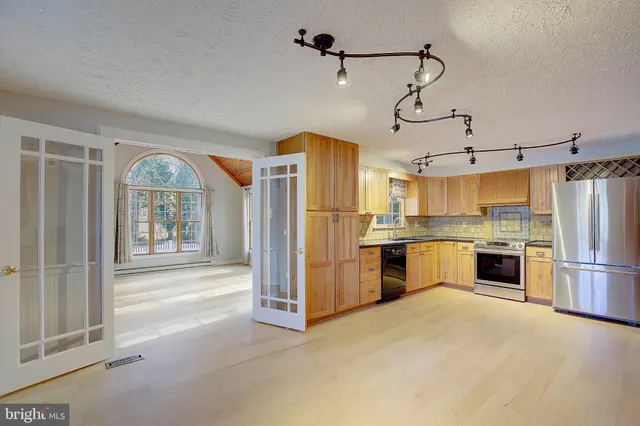 a kitchen with refrigerator a stove and cabinets
