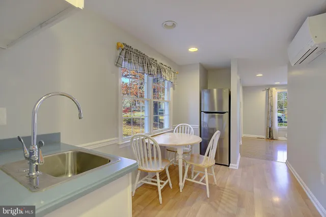 a kitchen with a dining table chairs and refrigerator