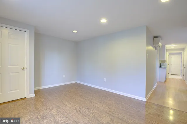 a view of a big room with wooden floor and a bathroom