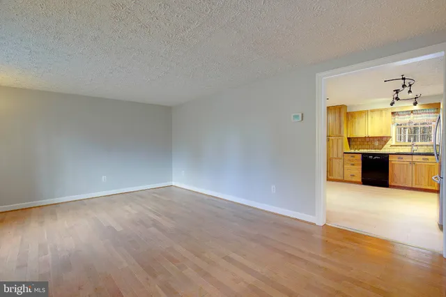 an empty room with kitchen and fireplace