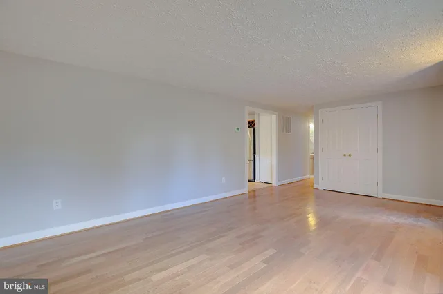 a view of an empty room with wooden floor