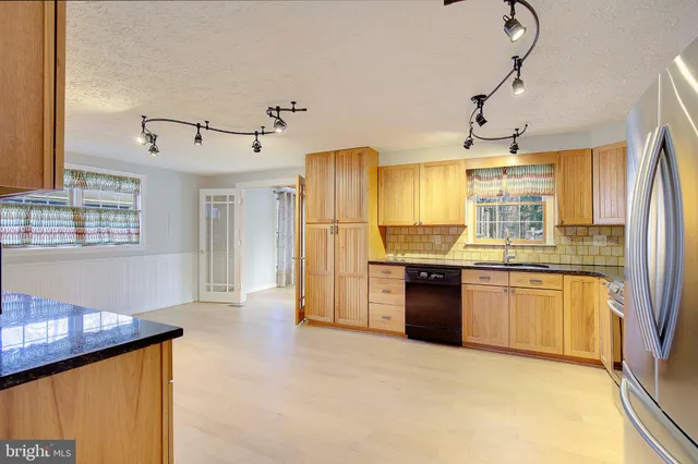 a kitchen with granite countertop refrigerator and cabinets