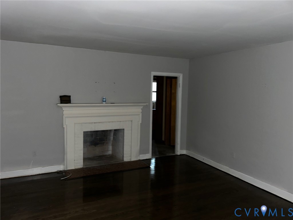 18722 Carson Road Dinwiddie, VA 23841 - Photo 5 of 10 a view of an empty room with wooden floor and a fireplace