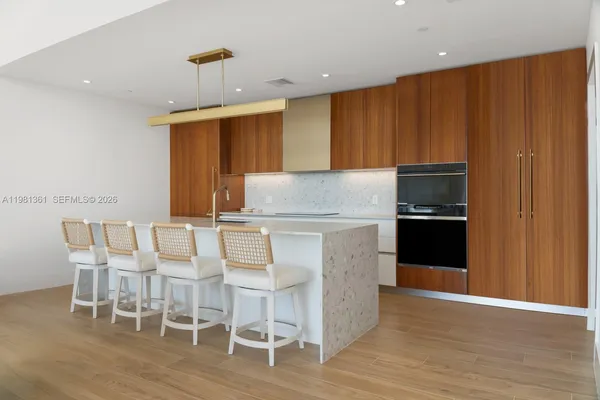 a kitchen with granite countertop a table chairs stove refrigerator and cabinets