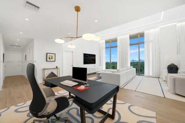 a living room with furniture a flat screen tv and a large window