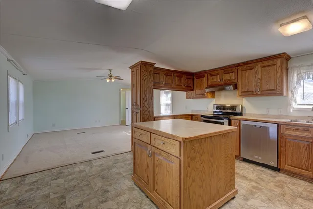 a kitchen with stainless steel appliances granite countertop a sink stove and cabinets