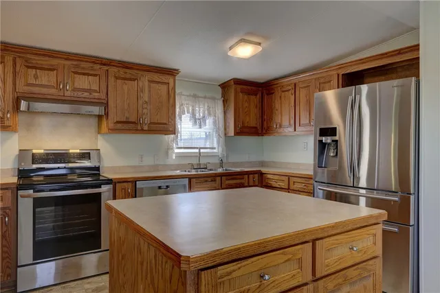 a kitchen with appliances a sink and cabinets