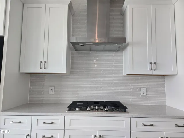 a kitchen with granite countertop white cabinets and stainless steel appliances