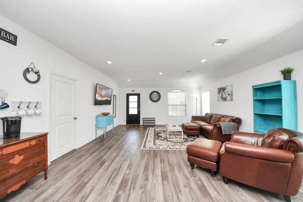 a living room with furniture and a wooden floor