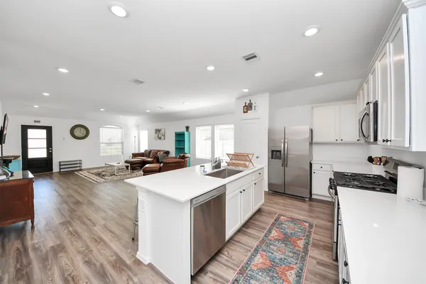 a kitchen with refrigerator a sink and a stove
