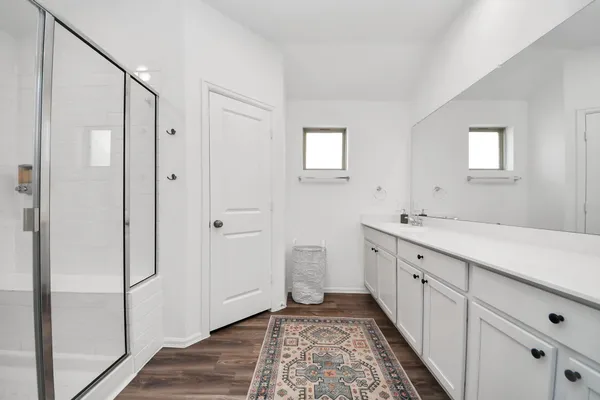 a spacious bathroom with double vanity and mirrors