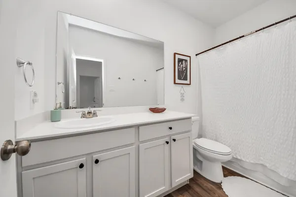 a bathroom with a granite countertop sink a toilet and a mirror