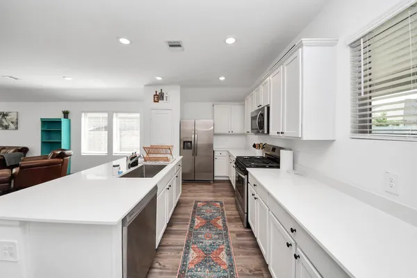 a large kitchen with stainless steel appliances lots of counter top space
