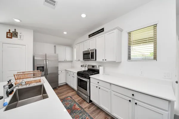 a kitchen with stainless steel appliances granite countertop a sink stove microwave and refrigerator