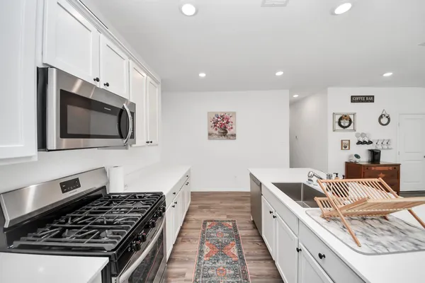 a kitchen with stainless steel appliances granite countertop a stove and a microwave
