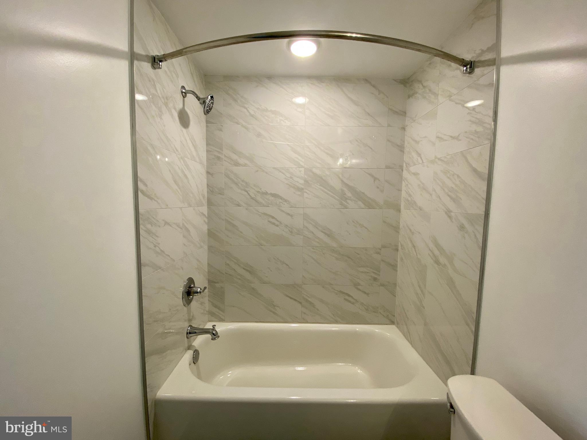 6615 Ridge Avenue, Unit 105 Philadelphia, PA 19128 - Photo 13 of 14 a bathroom with a shower and a bath tub