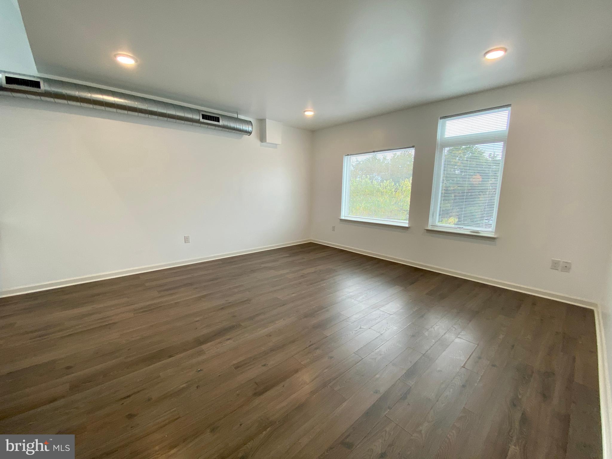 6615 Ridge Avenue, Unit 105 Philadelphia, PA 19128 - Photo 6 of 14 an empty room with wooden floor and windows