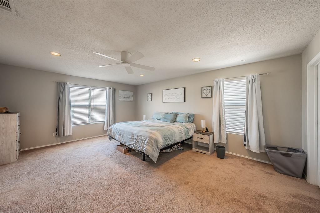 146 Independence Avenue Venus, TX 76084 - Photo 12 of 21 a spacious bedroom with a bed and a window