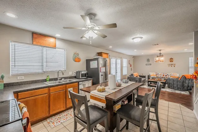 a dining hall with stainless steel appliances granite countertop a dining table and chairs