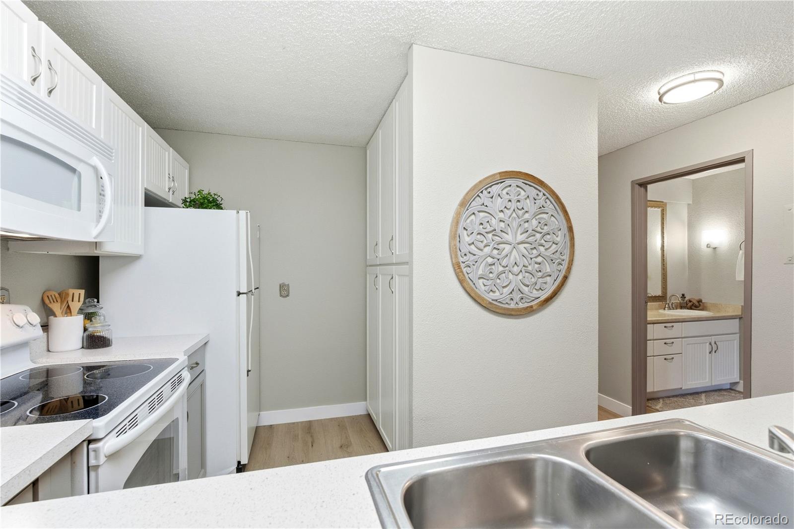 2880 South Locust Street, Unit 200S Denver, CO 80222 - Photo 12 of 43 a kitchen with stainless steel appliances granite countertop a sink and a refrigerator