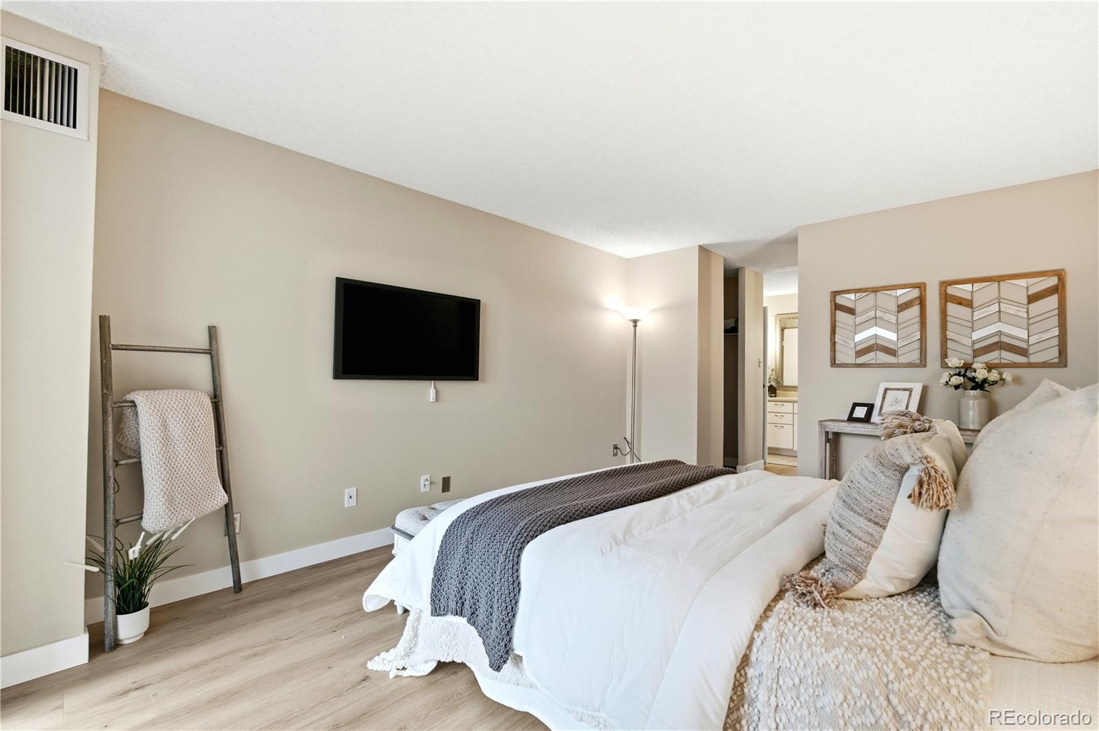 2880 South Locust Street, Unit 200S Denver, CO 80222 - Photo 15 of 43 a bedroom with a bed and a flat screen tv