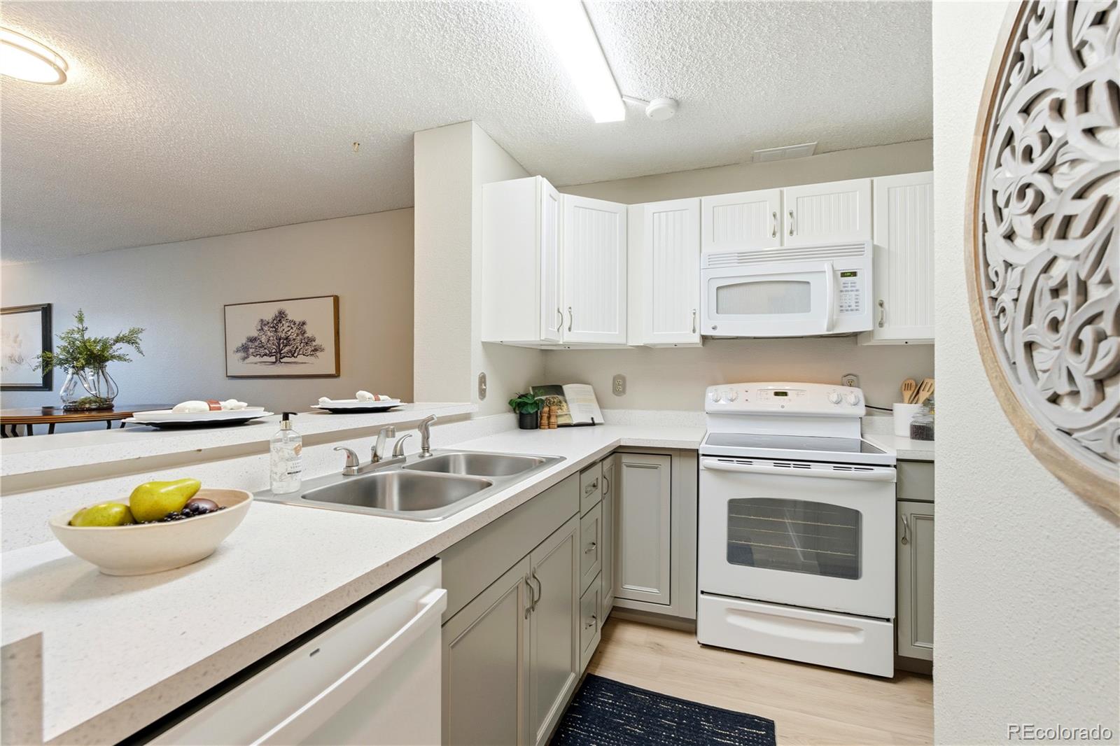 2880 South Locust Street, Unit 200S Denver, CO 80222 - Photo 10 of 43 a kitchen with a sink a stove cabinets and counter space