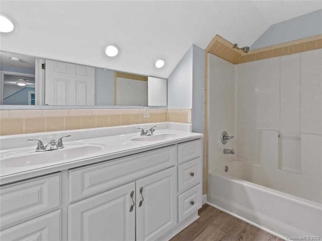 80 Sand Hill Road Asheville, NC 28806 - Photo 22 of 28 a bathroom with a sink a large mirror and a bathtub