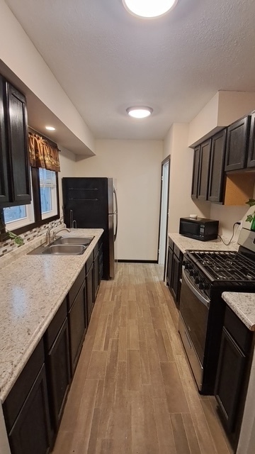 212 West Division Street Bloomington, IL 61701 - Photo 5 of 12 a kitchen with stainless steel appliances granite countertop a stove a sink and a refrigerator