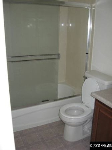 7679 Corso Street Reno, NV 89506 - Photo 3 of 7 a white toilet sitting next to a bath tub