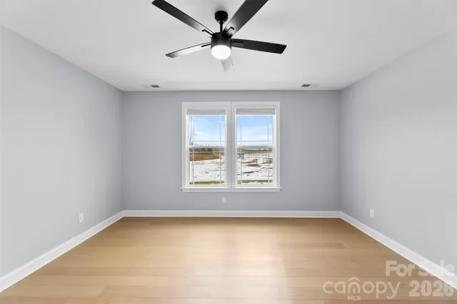an empty room with a window and a ceiling fan