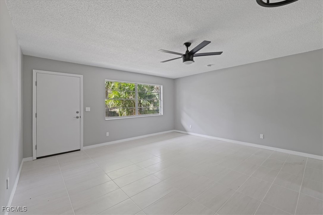 3225 East Riverside Drive, Unit 63F Fort Myers, FL 33905 - Photo 6 of 30 an empty room with windows and ceiling fan