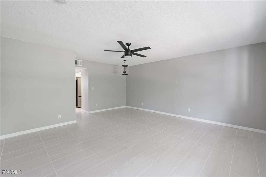 3225 East Riverside Drive, Unit 63F Fort Myers, FL 33905 - Photo 8 of 30 an empty room with a ceiling fan and a window