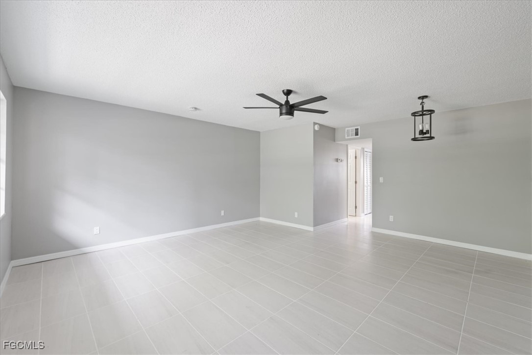 3225 East Riverside Drive, Unit 63F Fort Myers, FL 33905 - Photo 9 of 30 a view of an empty room with a chandelier fan