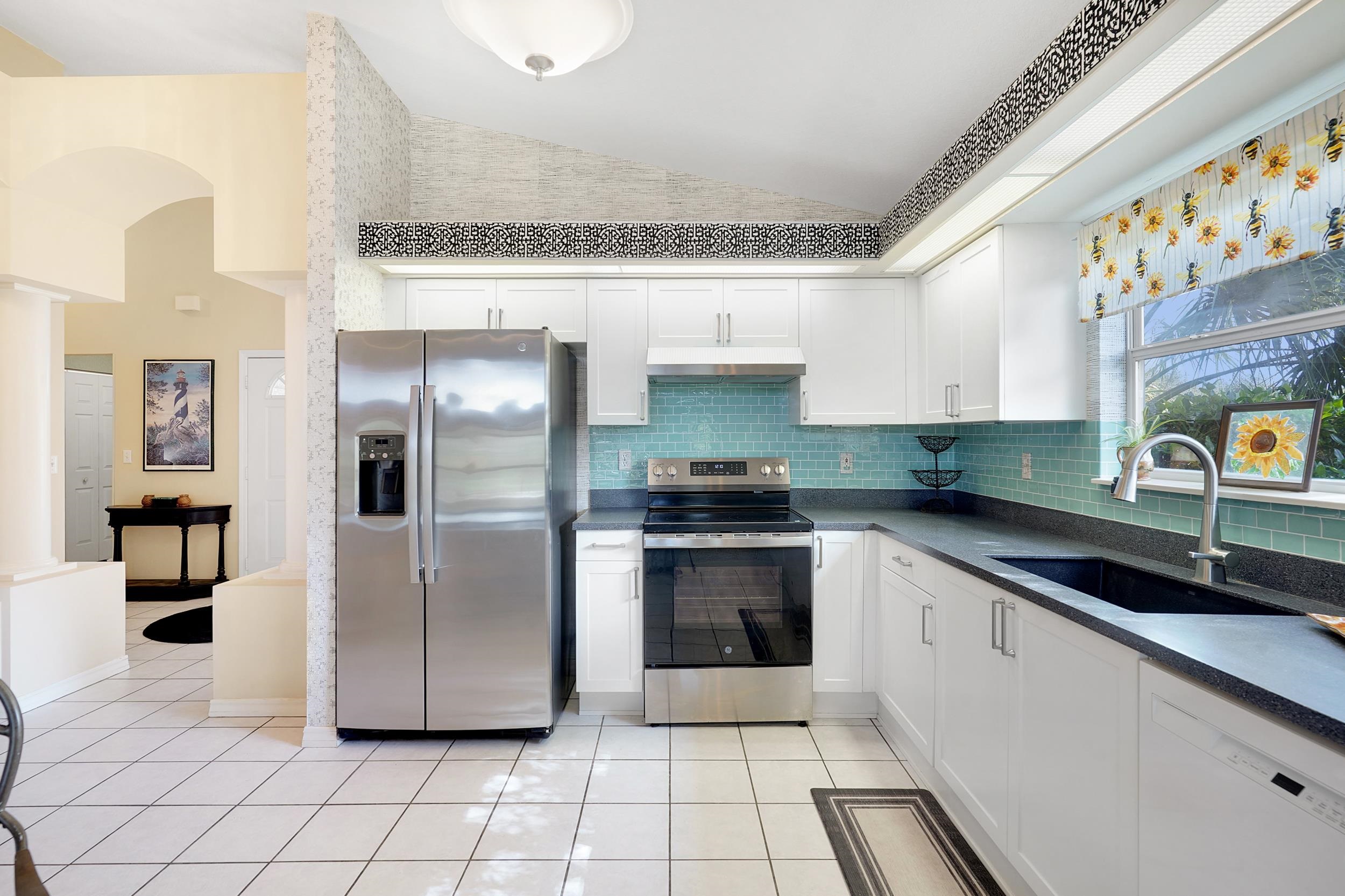 101 Marsh Place North St. Augustine, FL 32080 - Photo 16 of 42 a kitchen with stainless steel appliances granite countertop a sink and a refrigerator
