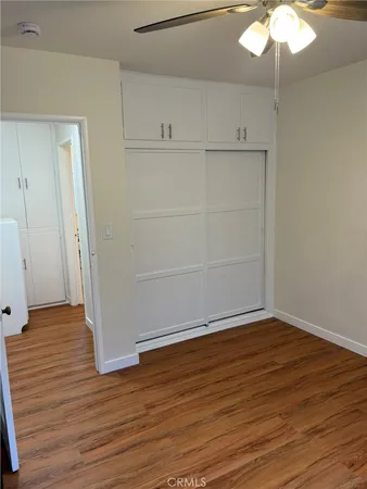 an empty room with wooden floor and white walls