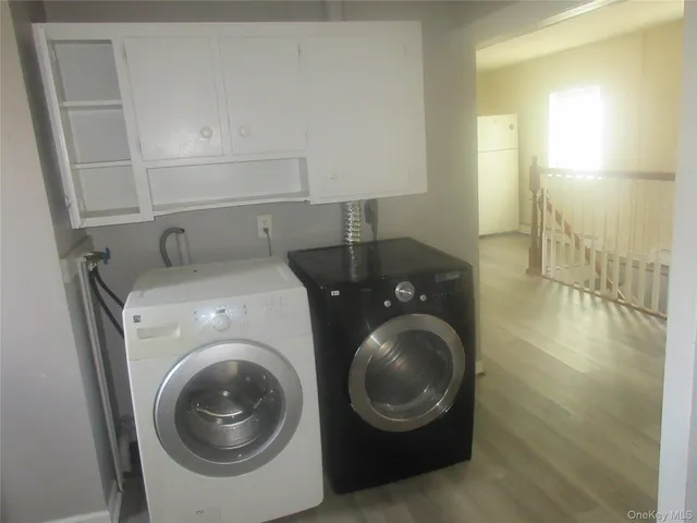 a utility room with wooden floor washer and dryer