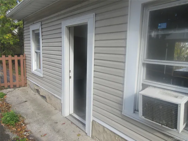 a view of front door and porch with wooden floor