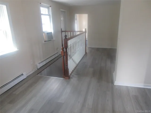 a view of a hallway with wooden floor and stairs