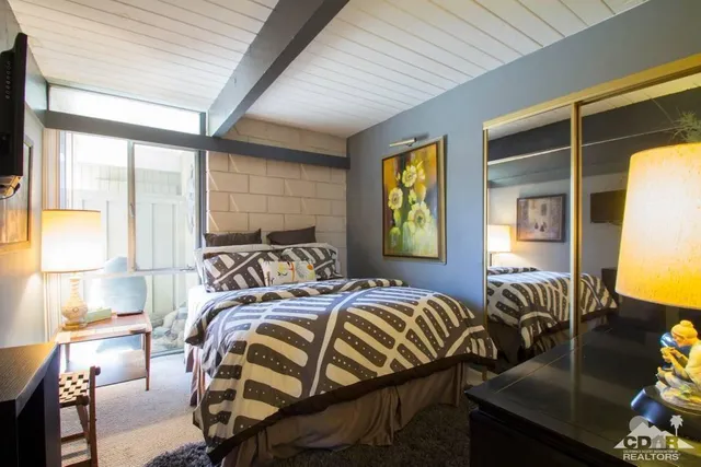 a bed sitting in a bedroom next to a window