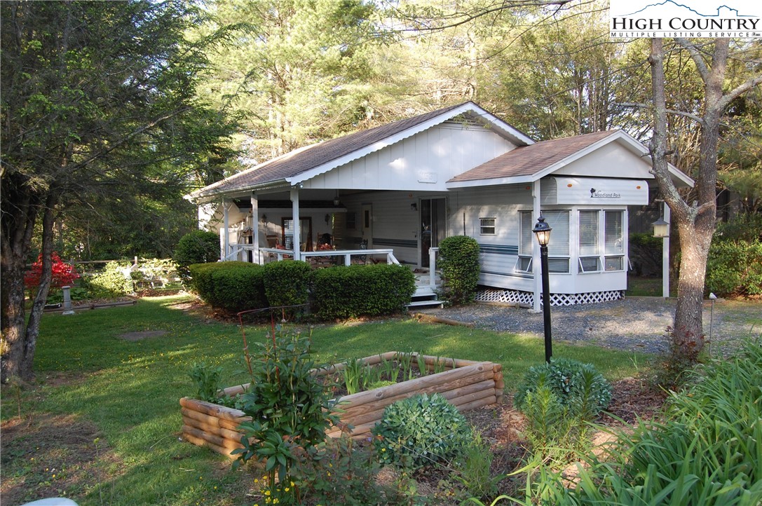 a view of a house with a yard and potted plants