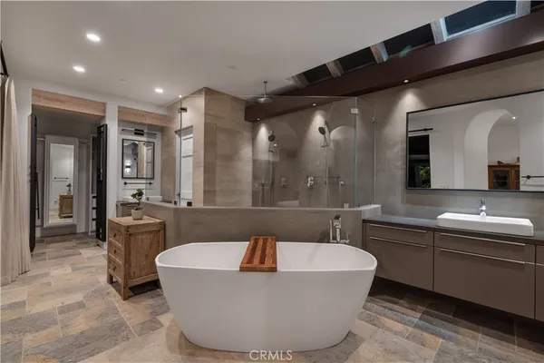 a bathroom with a tub a sink and a large mirror